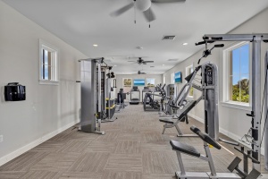 Professional interior photography by Realty Media 360 of a modern residential community gym featuring high-end strength training equipment and bright natural lighting.
