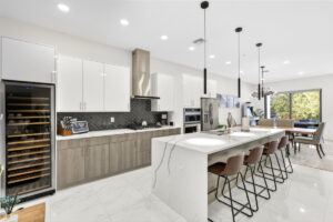 Luxury Sarasota FL kitchen by Realty Media 360 with a white oak island, fluted cabinetry, and bold marble countertops.