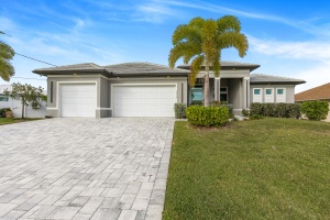 Professional HDR exterior photograph of a modern single-story home by Realty Media 360 with a blue sky, paved driveway, and manicured landscaping.