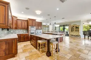 Luxury open-concept kitchen in Bradenton FL by Realty Media 360 showing the flow from the gourmet island to the living area.
