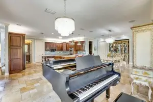 Luxury music room in Bradenton FL by Realty Media 360 featuring a grand piano and expansive natural light.