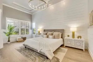 Professional interior photograph by Realty Media 360 of a luxury master bedroom featuring a tray ceiling, shiplap accent wall, and bright natural lighting.